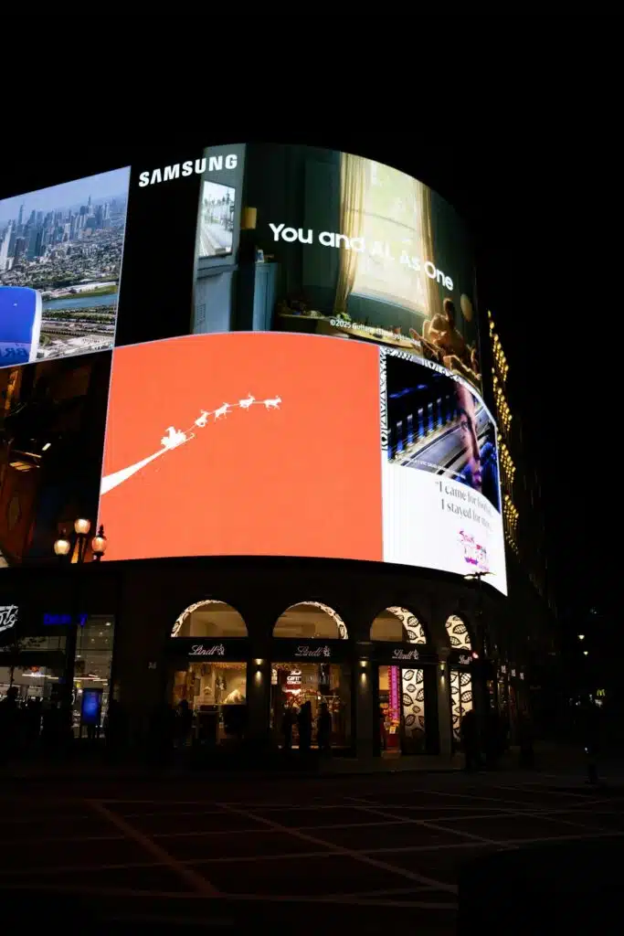 Vallas publicitarias digitales iluminando una esquina de la ciudad por la noche